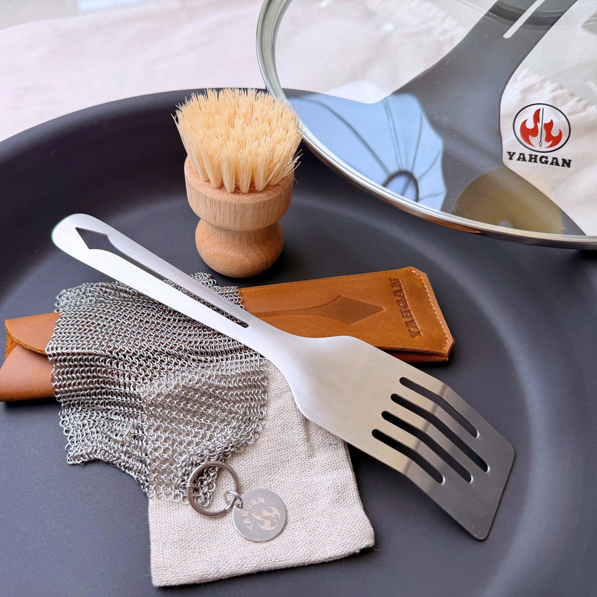 Yahgan 30cm Master Bundle contents: carbon steel pan, glass lid, leather handle sleeve, care kit and Mano spatula
