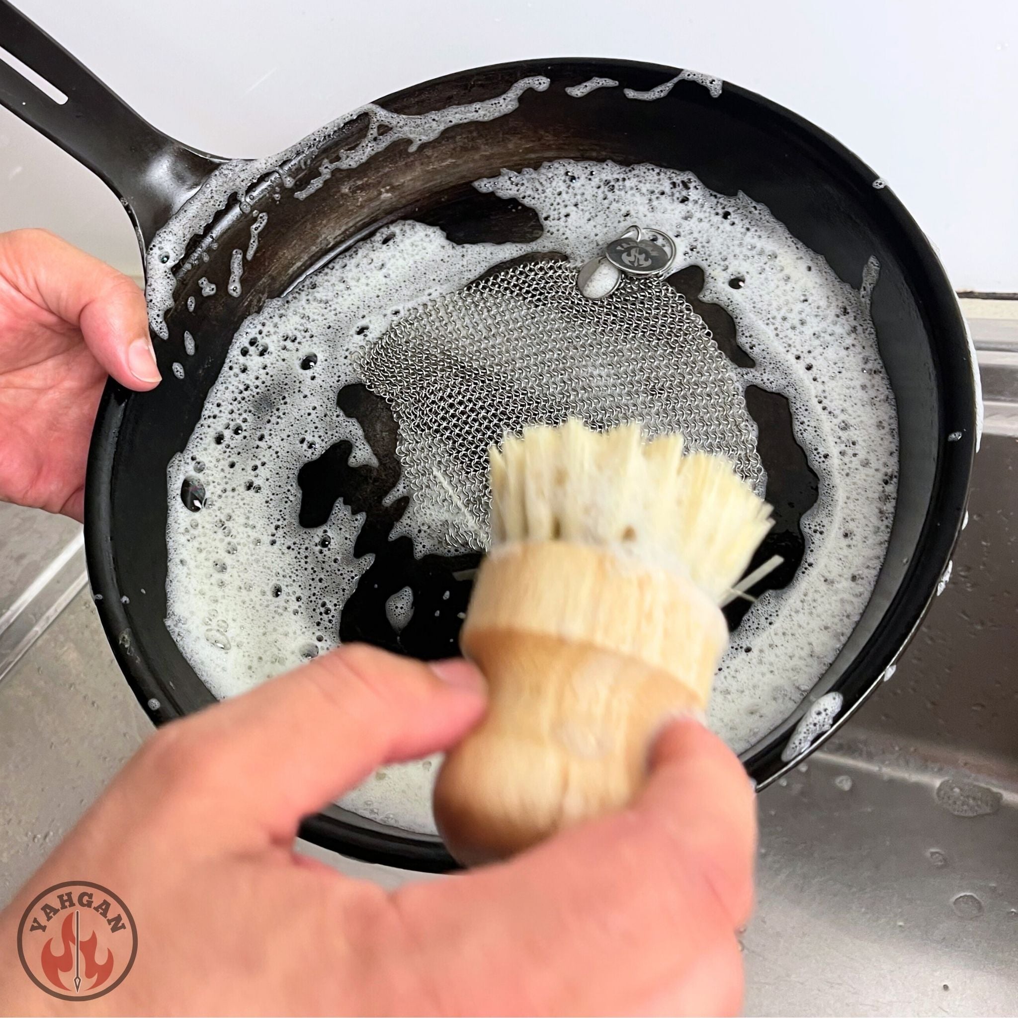 Using Yahgan chainmail scrubber and sisal brush to clean Black Series 26cm carbon steel pan in kitchen sink