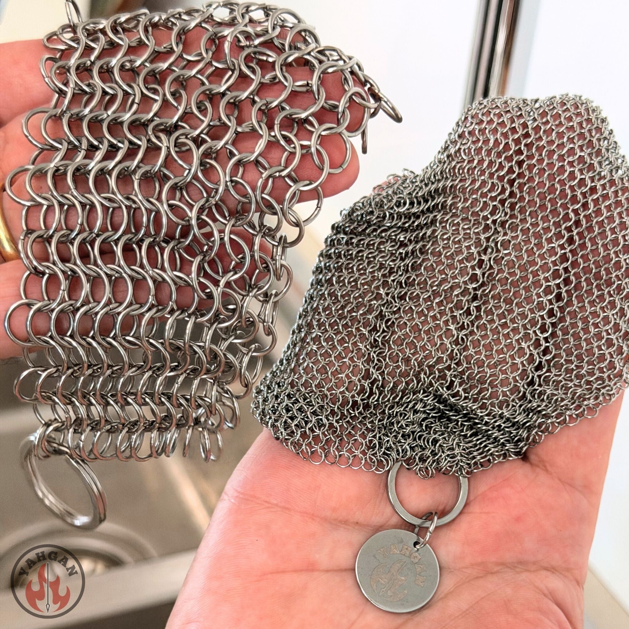Side-by-side comparison of Yahgan 3.8mm chainmail scrubber vs standard 8mm chainmail held in hands — more contact points per cm²