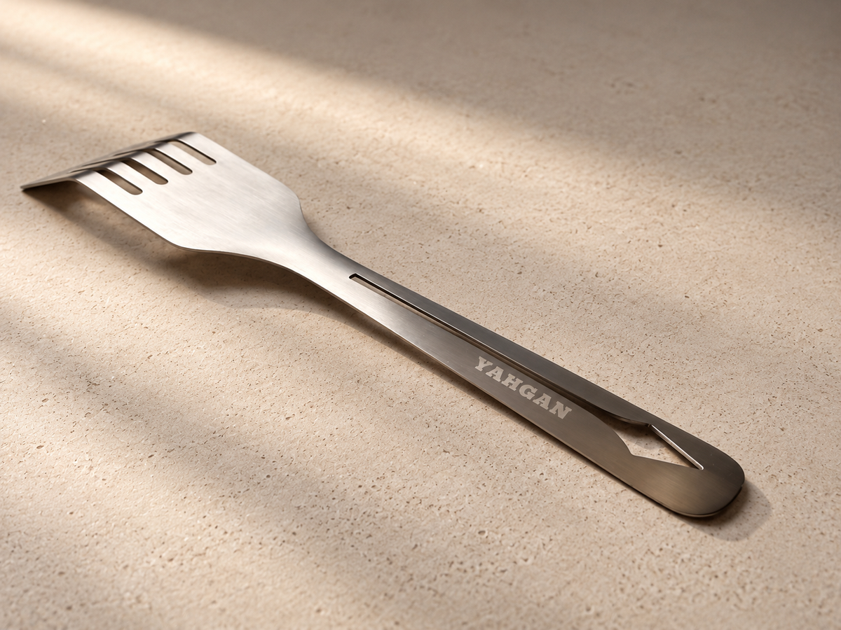 Yahgan Mano spring stainless steel spatula resting on stone