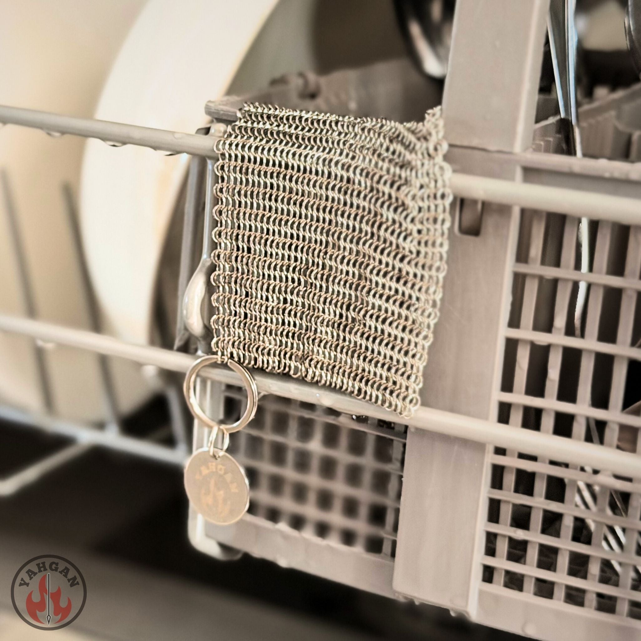 Yahgan 316L stainless steel chainmail scrubber hanging in dishwasher rack — dishwasher safe care kit
