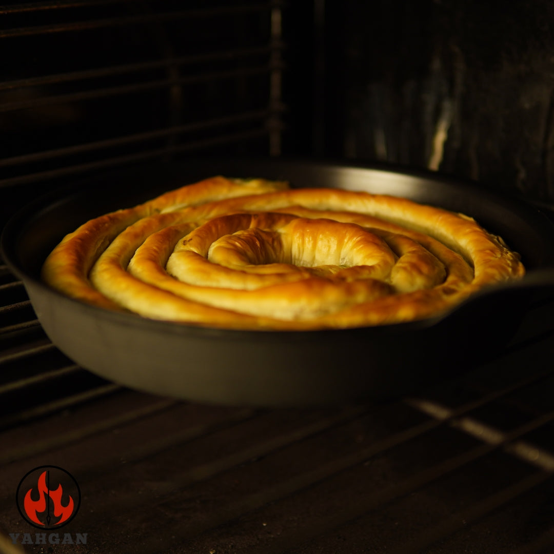 Yahgan Classic Series carbon steel pan in oven with spanakopita pastry  — oven safe, goes from stovetop to oven with ease