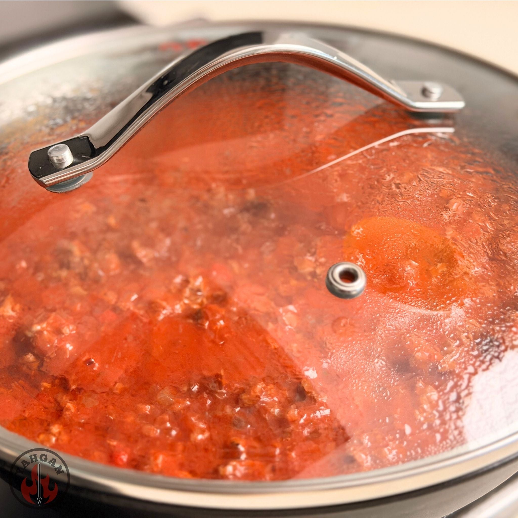 Red tomato sauce simmering in Yahgan carbon steel pan on stovetop